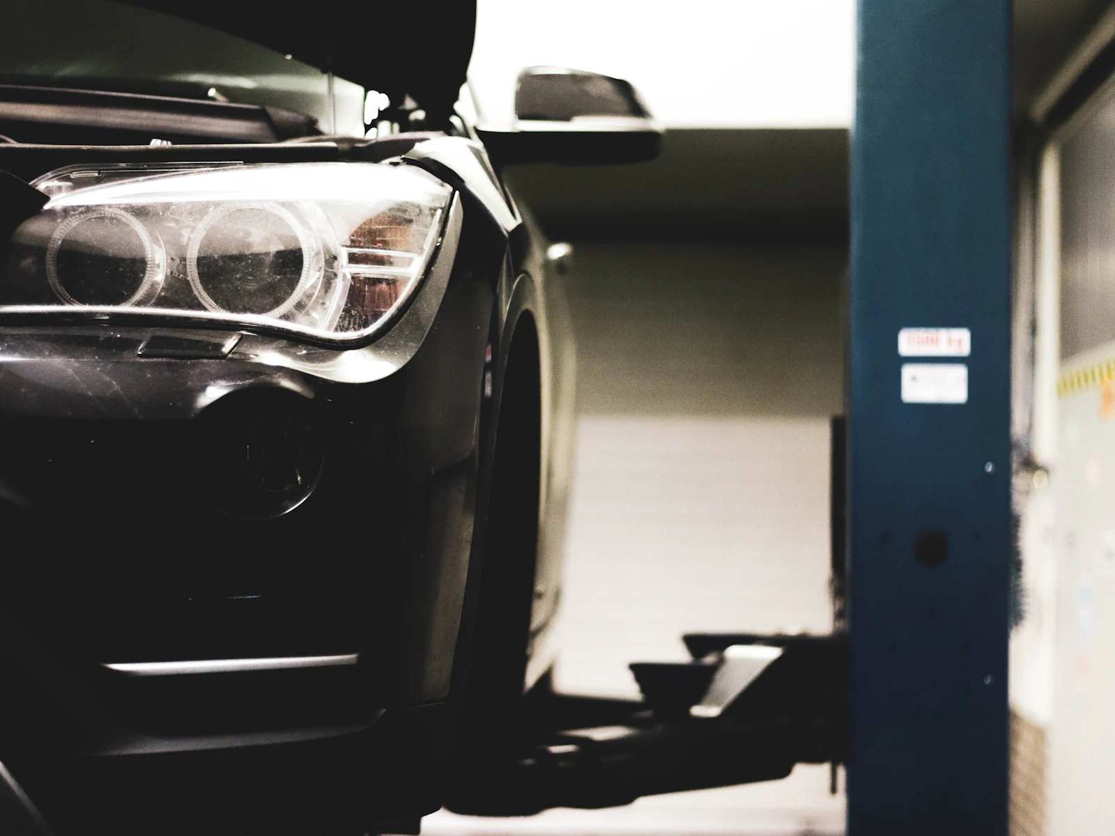 The front of a dark car parked in a garage bay